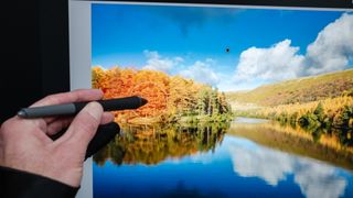 A hand drawing on a picture of trees next to a lake on an XPPen Artist Pro 24 (Gen 2) 4K drawing tablet