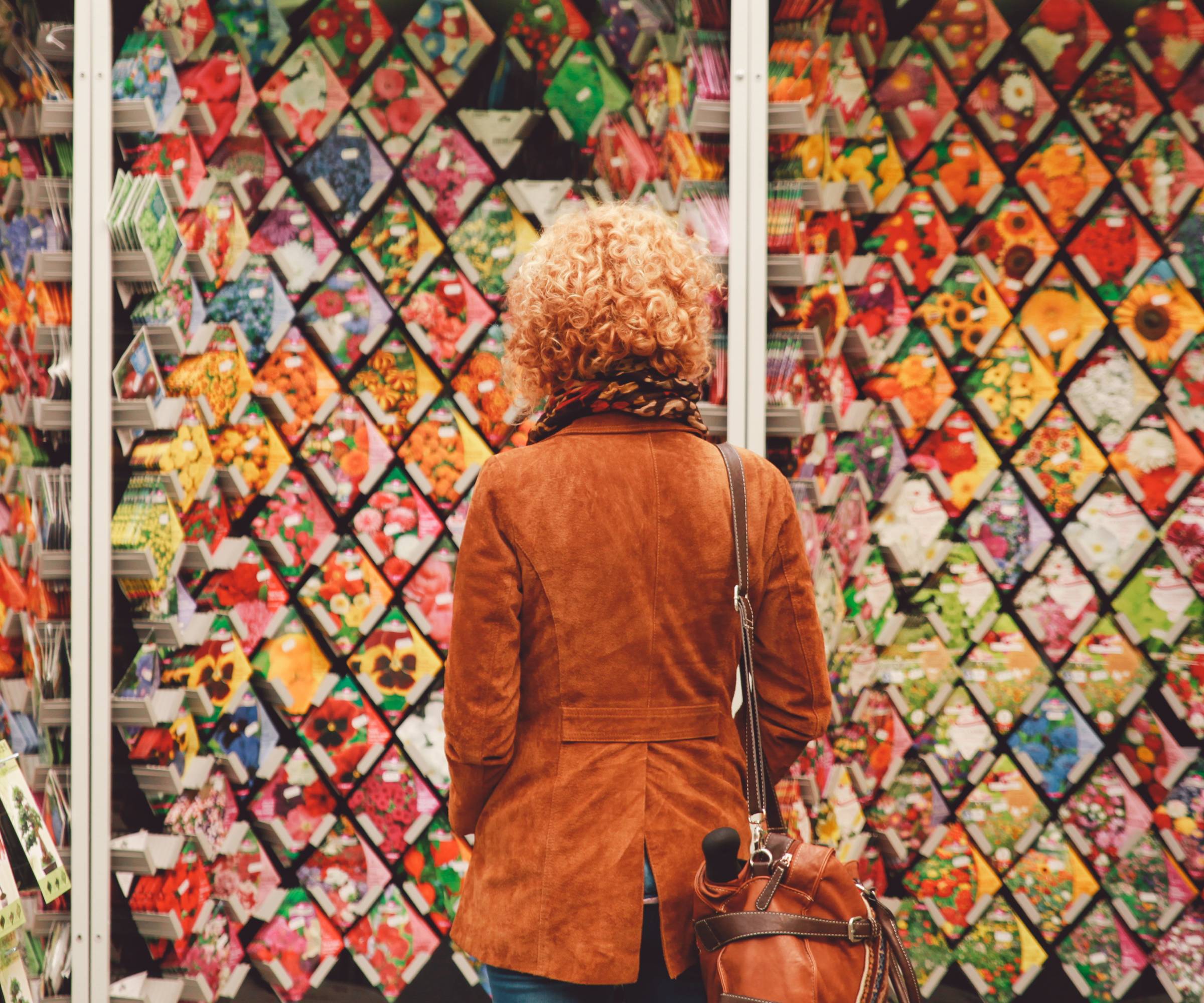 The back of a woman looking at walls of seeds for sale