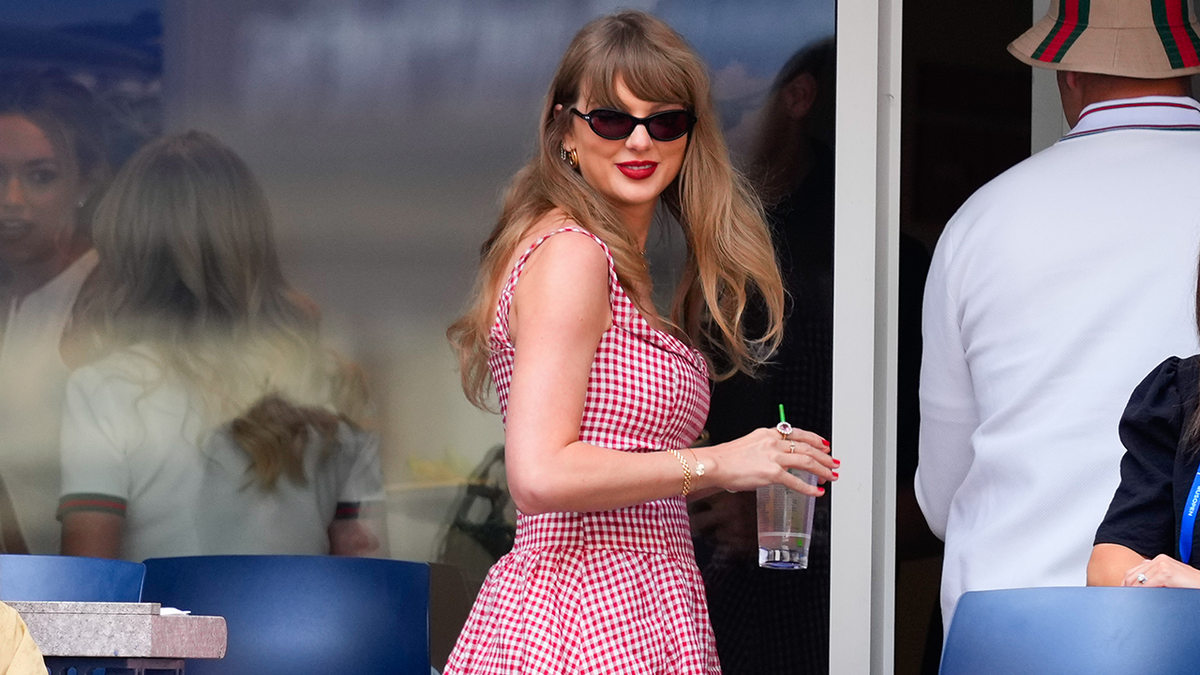 Taylor Swift is seen during the 2024 US Open Tennis Championships wearing red and white gingham Reformation dress