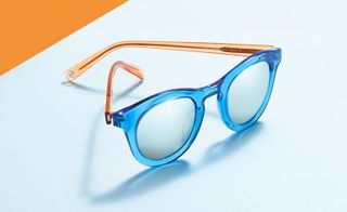 A pair of sunglasses with blue frames and orange legs
