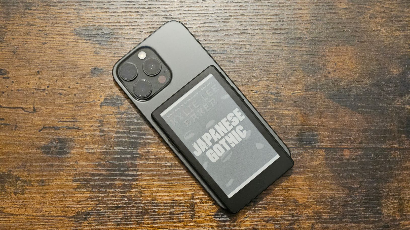 The Xteink X4 Pro attached to an iPhone 16 Pro Max