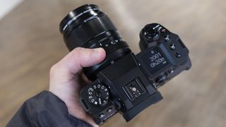 A hand holding the Fujifilm X-H2S camera