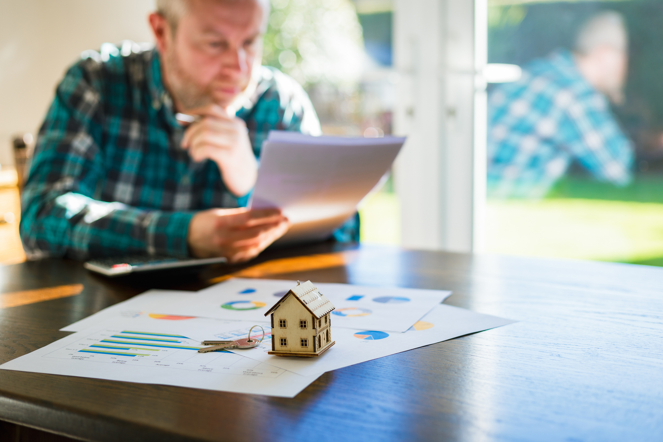 A man is looking at documents pertaining to a house sale agreement.