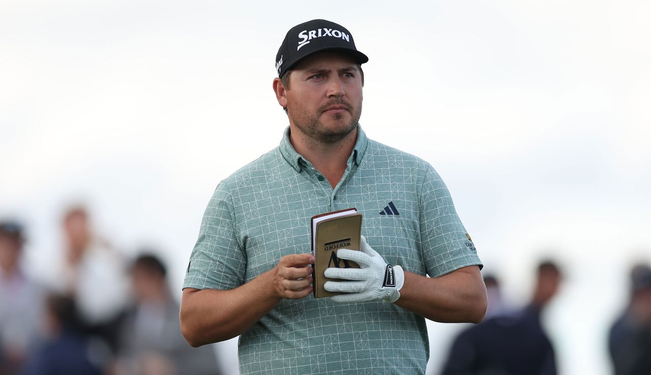 Andrew Novak walks down the fairway whilst checking his yardage book