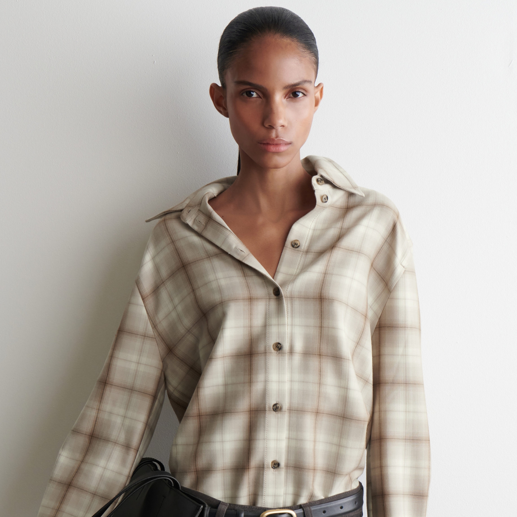 Model wearing a plaid shirt from from COS. 