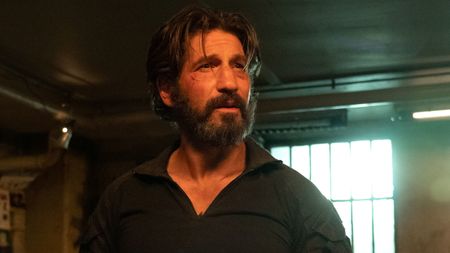 A bearded Jon Bernthal looks upset in a dingy looking room in Daredevil: Born Again.