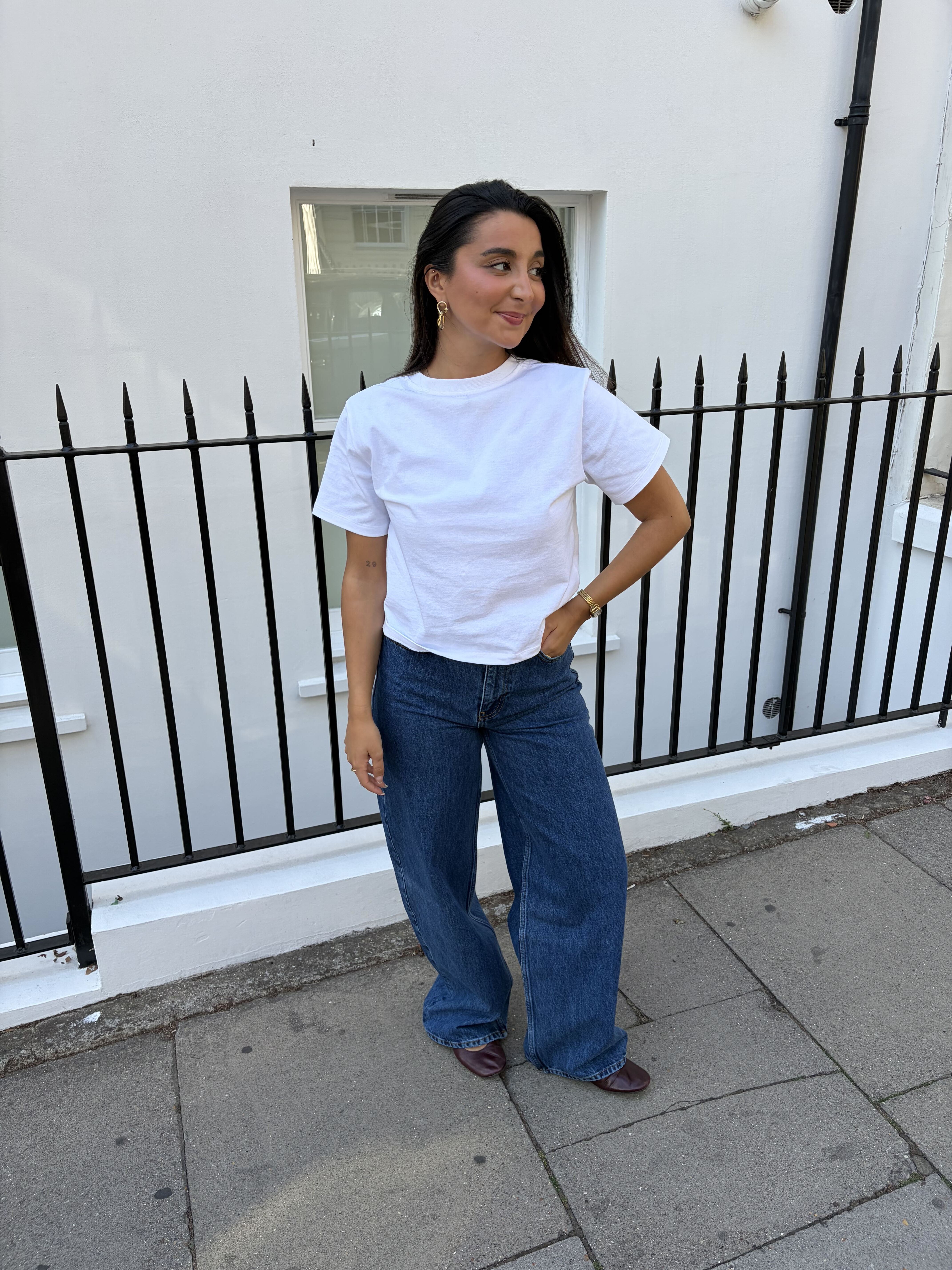 Marina wearing white tee and wide-leg jeans