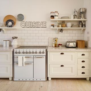 White range cooker in a kitchen with white cabinets, white wall tiles and wall shelves