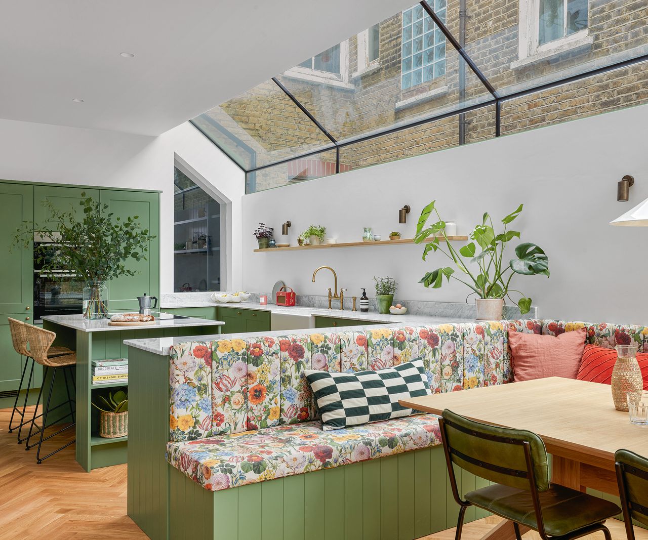 A kitchen extension in a london terraced house with pitched glazed roof and built in seating family dining area