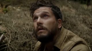 Kit Harrington looking up into the sky, very puzzled, in 2024's The Beast Within.