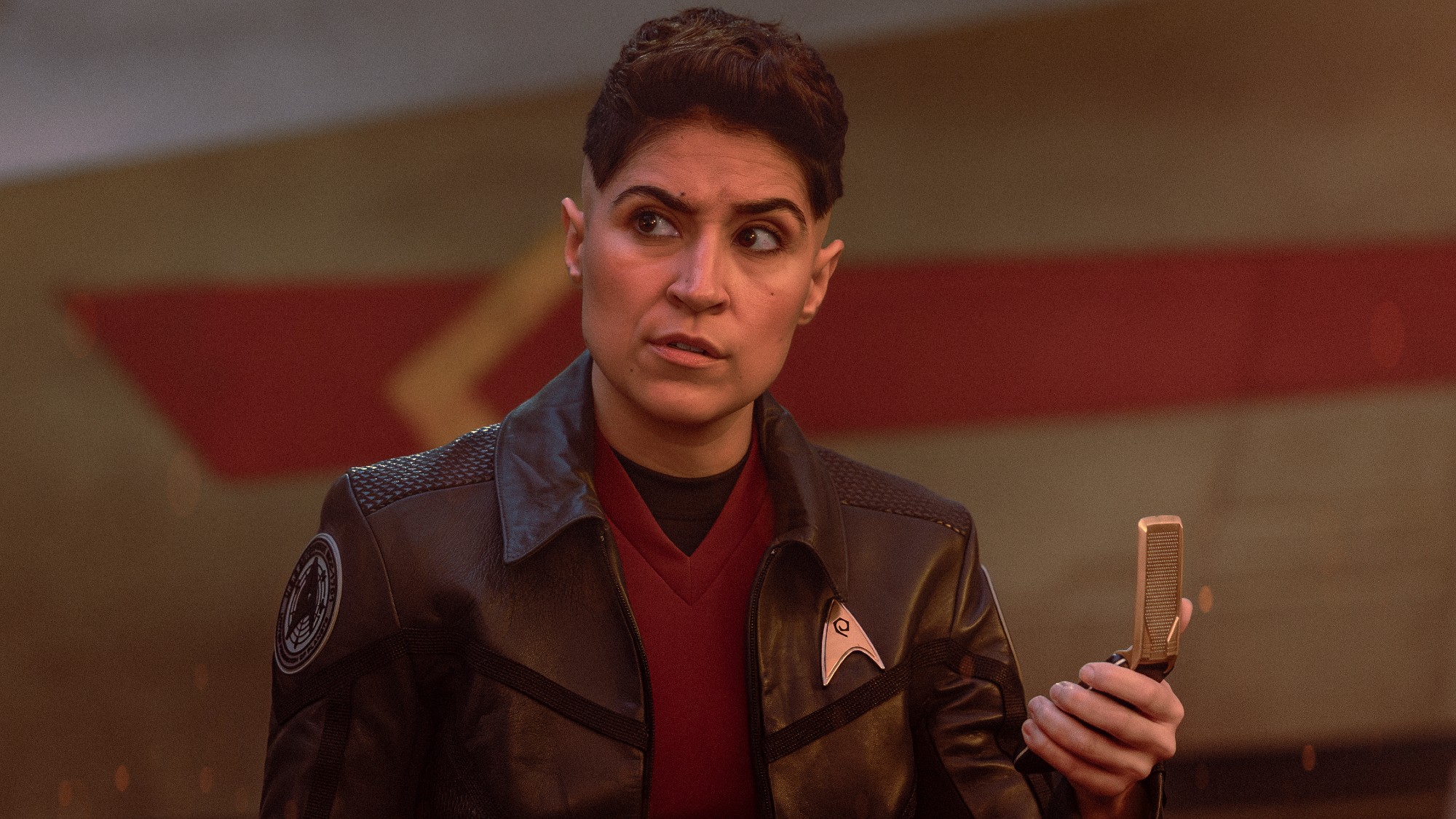 Ortegas looks around with her communicator. 