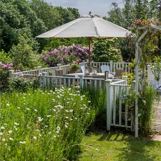 Wildflowers in wildflower garden next to decking railing surrounding outdoor seating area