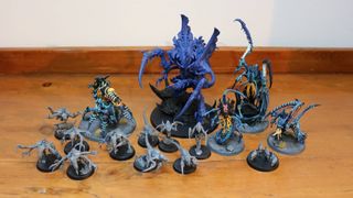 The full collection of new Tyranid models on a wooden table