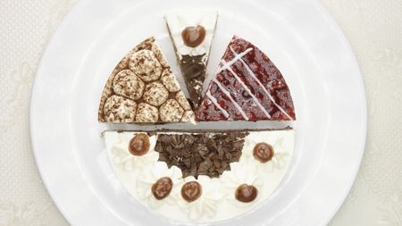 A white plate holding four different flavors of cheesecake.