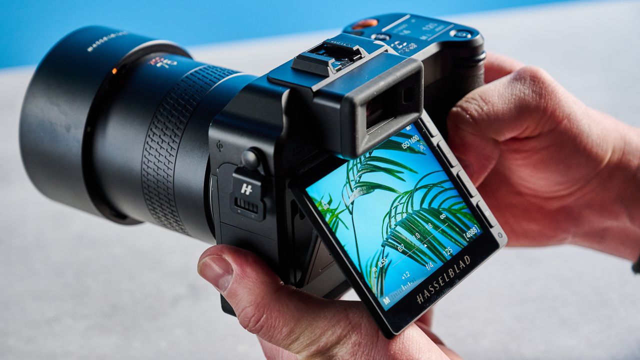 The Hasselblad X2D 100C in hand with the rear screen flipped up.