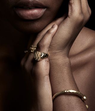 Woman wearing gold bracelets and rigs