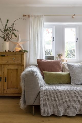 A Victorian cottage living room with large grey sofa and scandi style decor