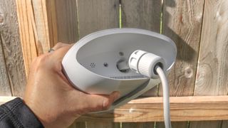 Plugging in an AC adapter into the bottom of the Eero Outdoor 7