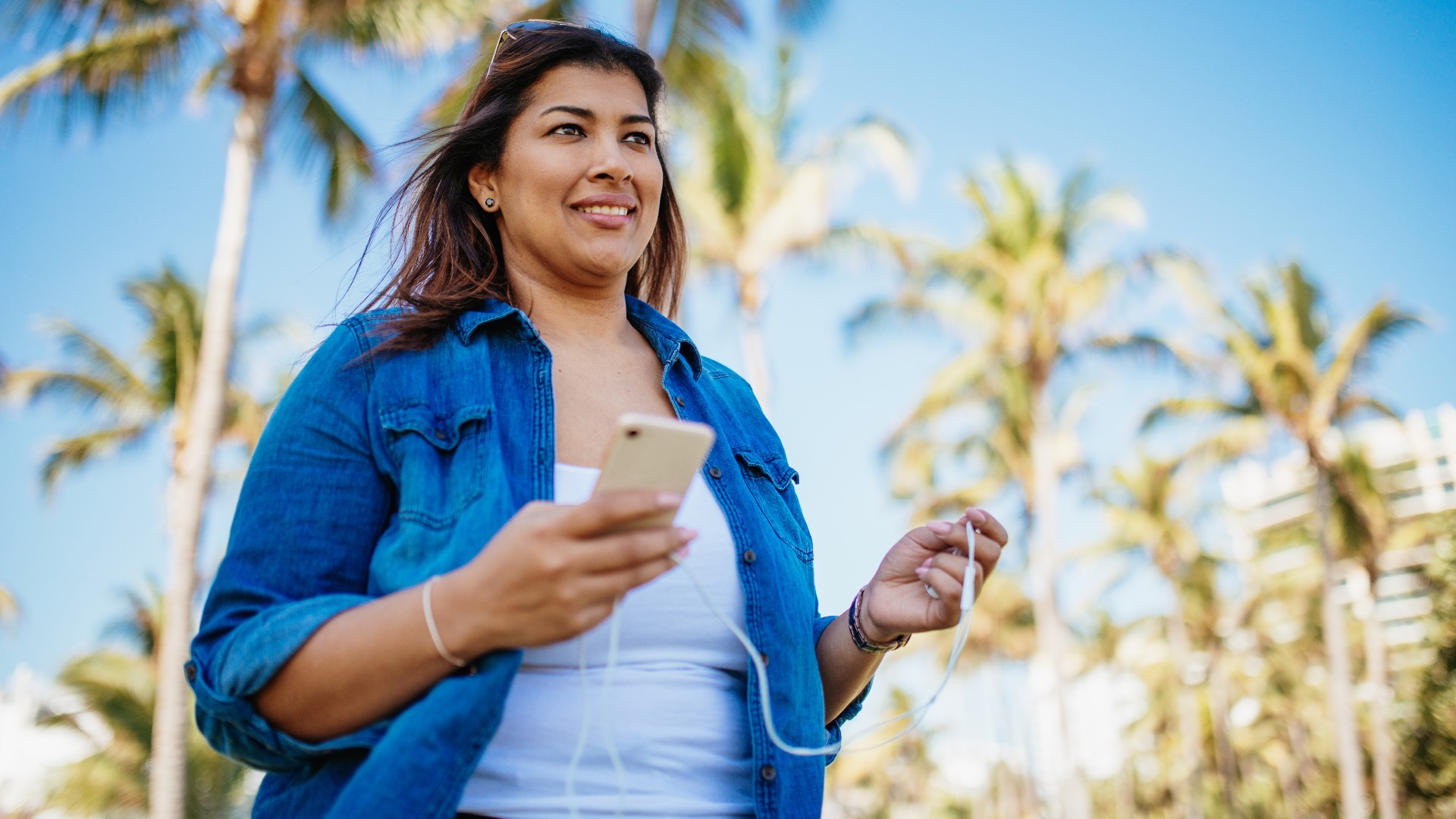 Mujer caminando sosteniendo su teléfono