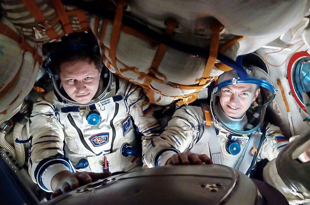 Roscosmos cosmonauts Andrei Babkin (left) and Nikolai Tikhonov, seen here during a Soyuz fit check in 2018, have been removed from the Soyuz MS-16 mission to the International Space Station after Tikhonov was reportedly injured during training. 