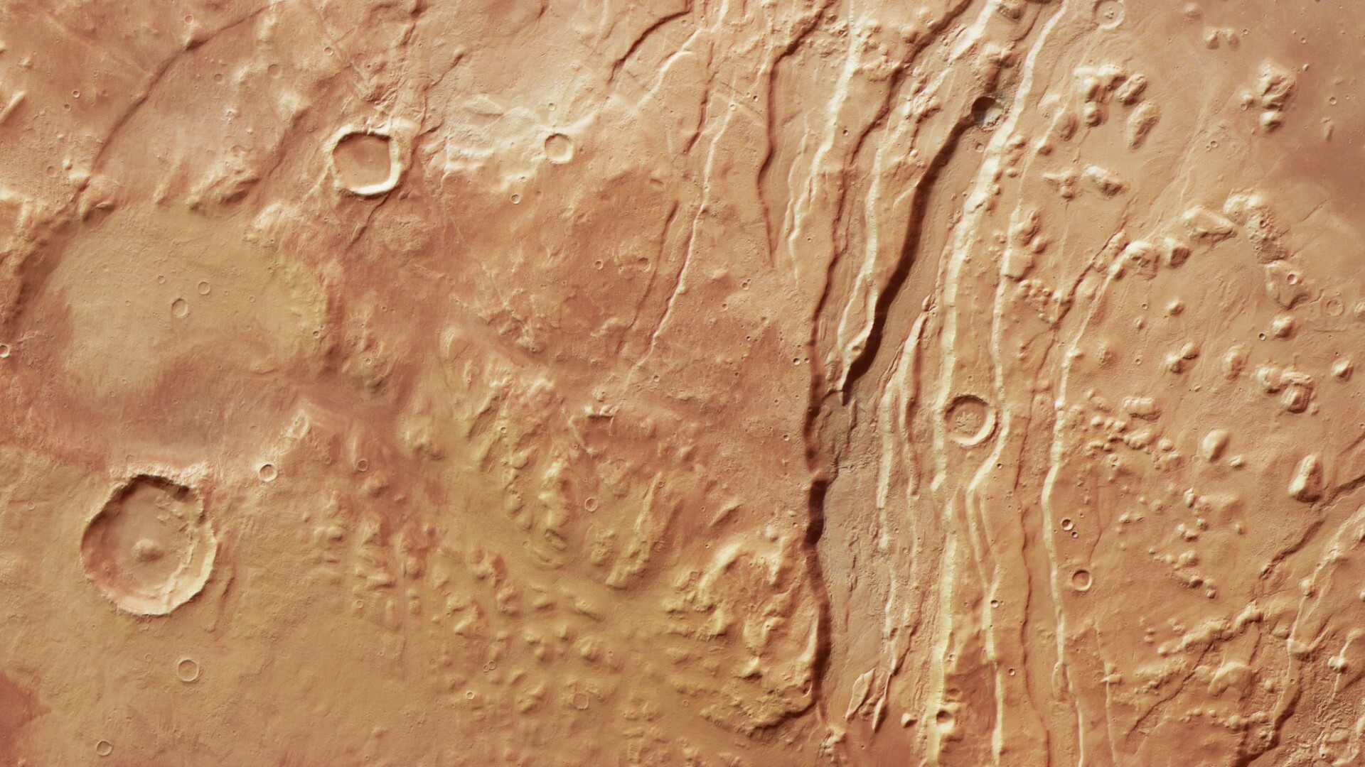 A series of streaks and dots in a muddy brownish reddish surface on the planet Mars. 