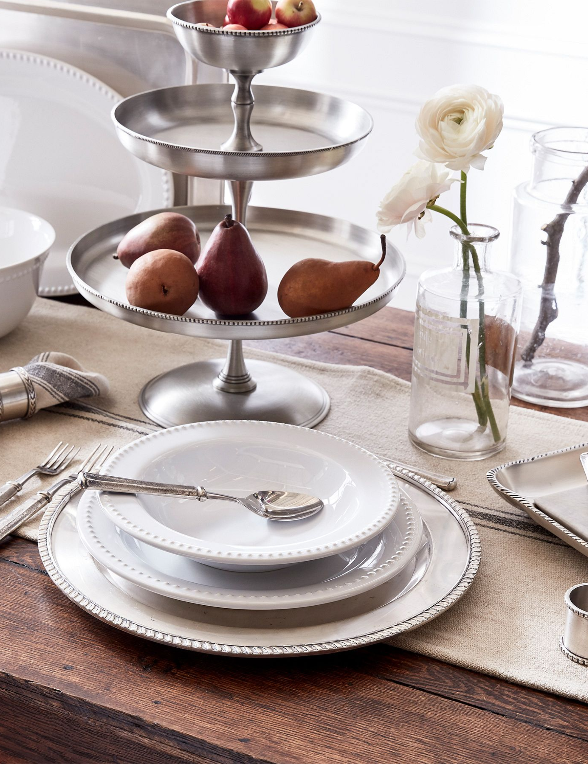 Classic rustic tablescape featuring bead-bordered porcelain plates and silver serveware.
