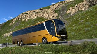 A gold MAN Lion&rsquo;s Coach drives along a winding mountain road in Euro Truck Simulator 2, surrounded by rocky hills and greenery under a bright blue sky, with a small &ldquo;Work in Progress&rdquo; label on screen.