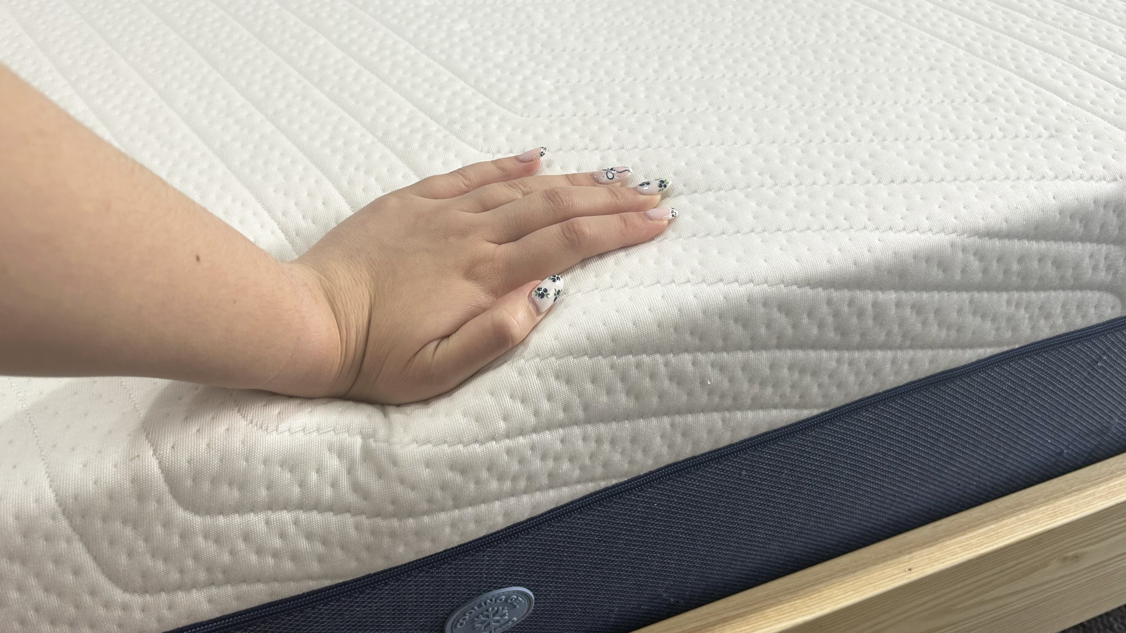 Hand pressing on top of mattress