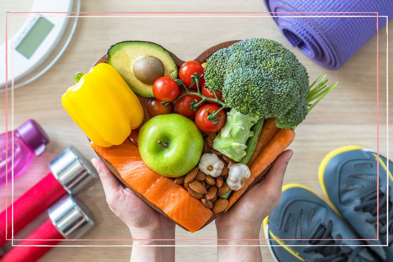 A bowl of fruit and veg in a heart shape, surrounded by exercise equipment