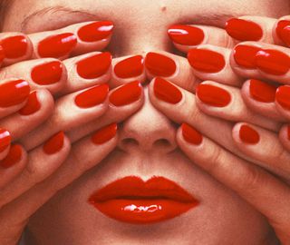 Guy bourdin photograph of woman with hands with red nails covering eyes