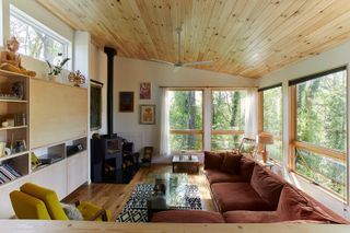 A modern living room space with a brown sofa and mustard yellow accent chair