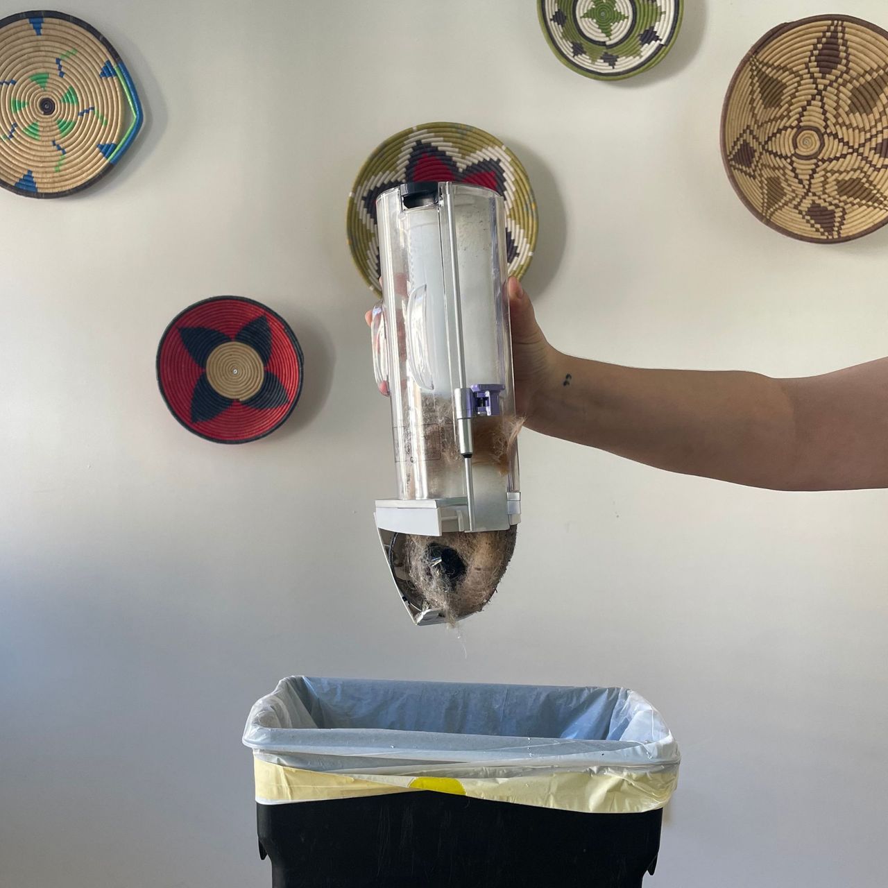 Emptying the Gtech Airram Platinum over a small kitchen bin