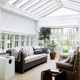 white conservatory with sofa set and potted plants
