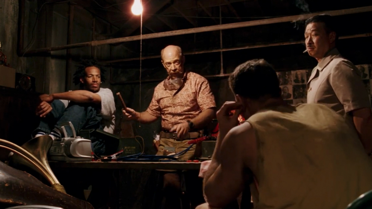 J.K. Simmons, Marlon Wayans, and others sitting around a table in The Ladykillers