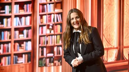 drew barrymore standing in front of a bookcase