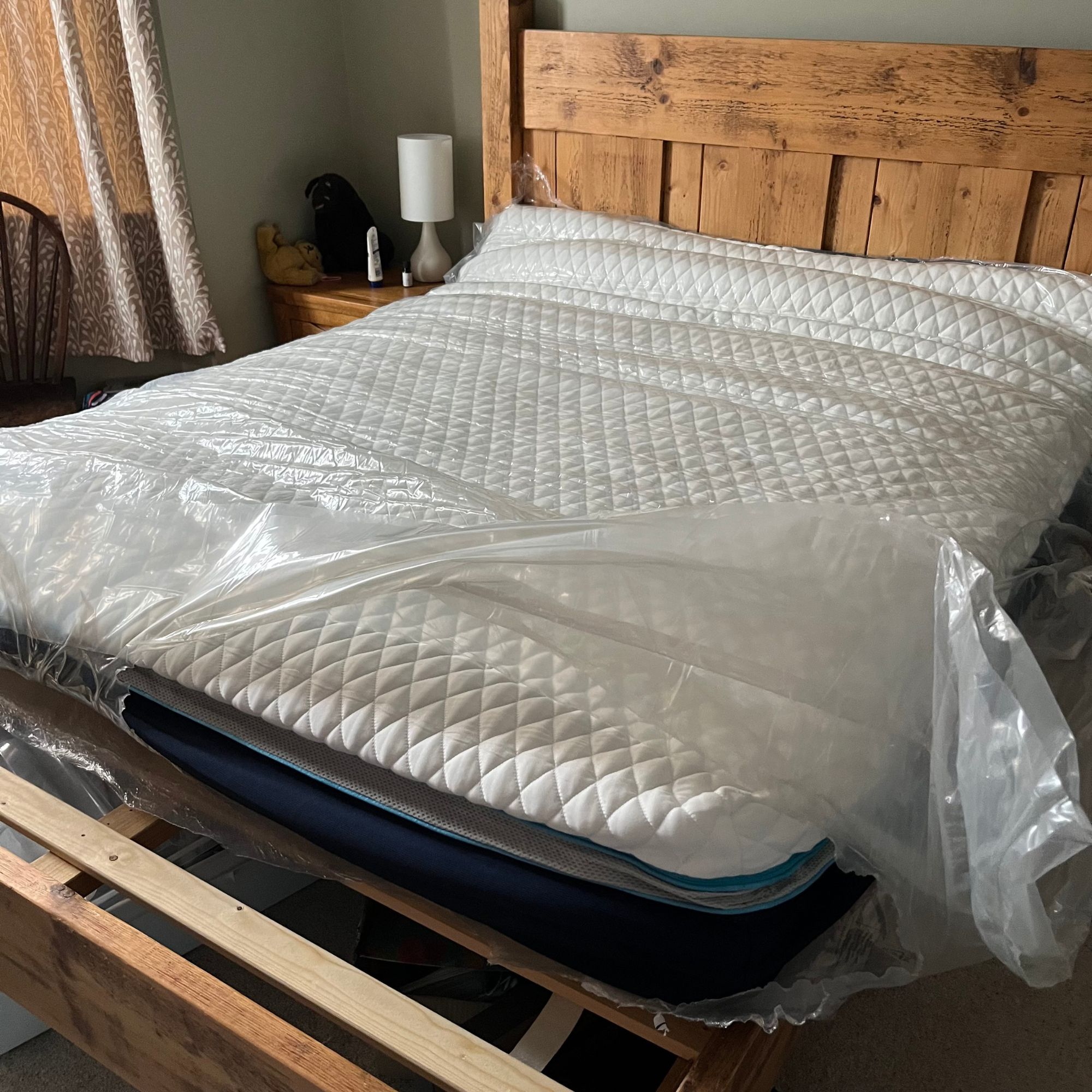 removing the plastic packaging from the Simba Hybrid Luxe Mattress on bed frame