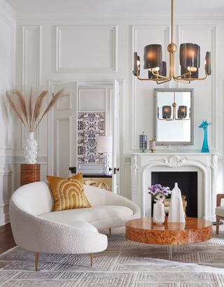 living room with white panelling curved sofa and white fireplace
