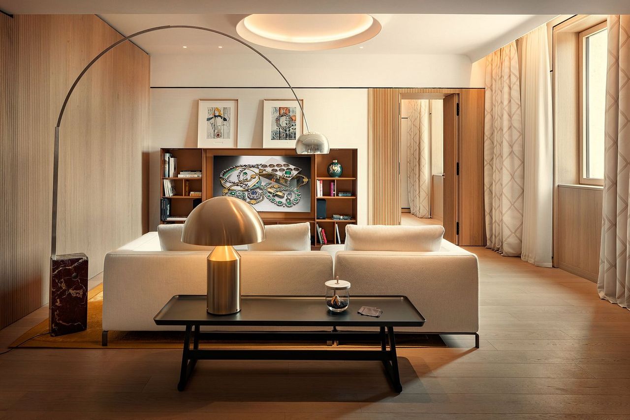 A sleekly furnished hotel suite features chrome and neutral furniture.