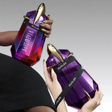 Two Mugler Alien perfume bottles being held