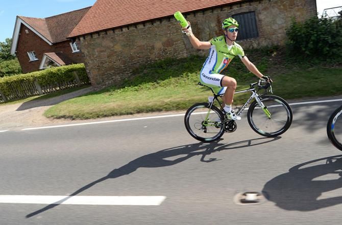 Peter Sagan (Cannondale) rides amongst peloton, holding up his water bottle to get a refill.