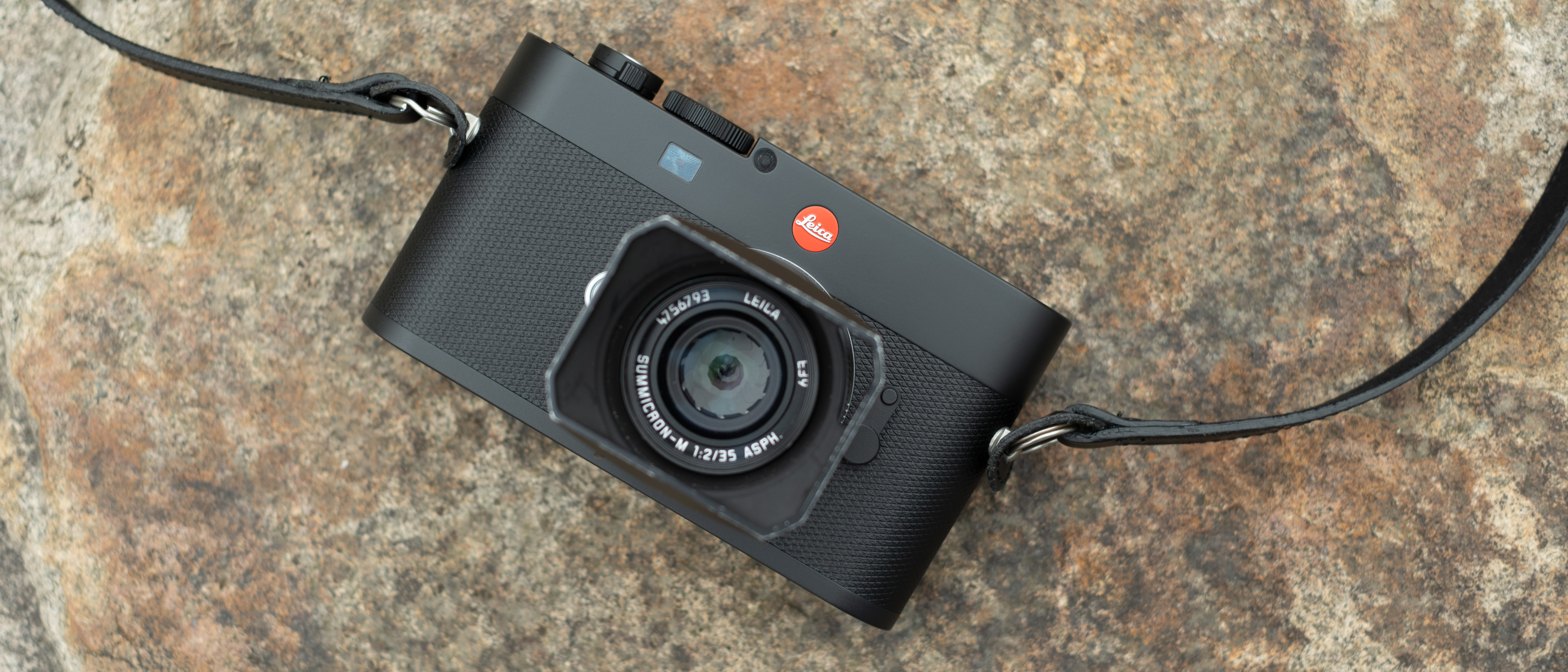 Leica M EV1 digital camera with lens attached on a stone surface