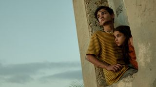 Adam (Zain Al Rafeea) and Jana (Riman Al Rafeea) look out a window in Netflix's "The Sand Castle"