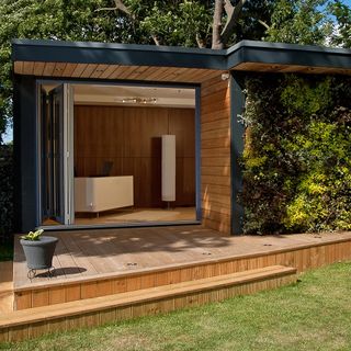 A garden room with a deck area and a living wall