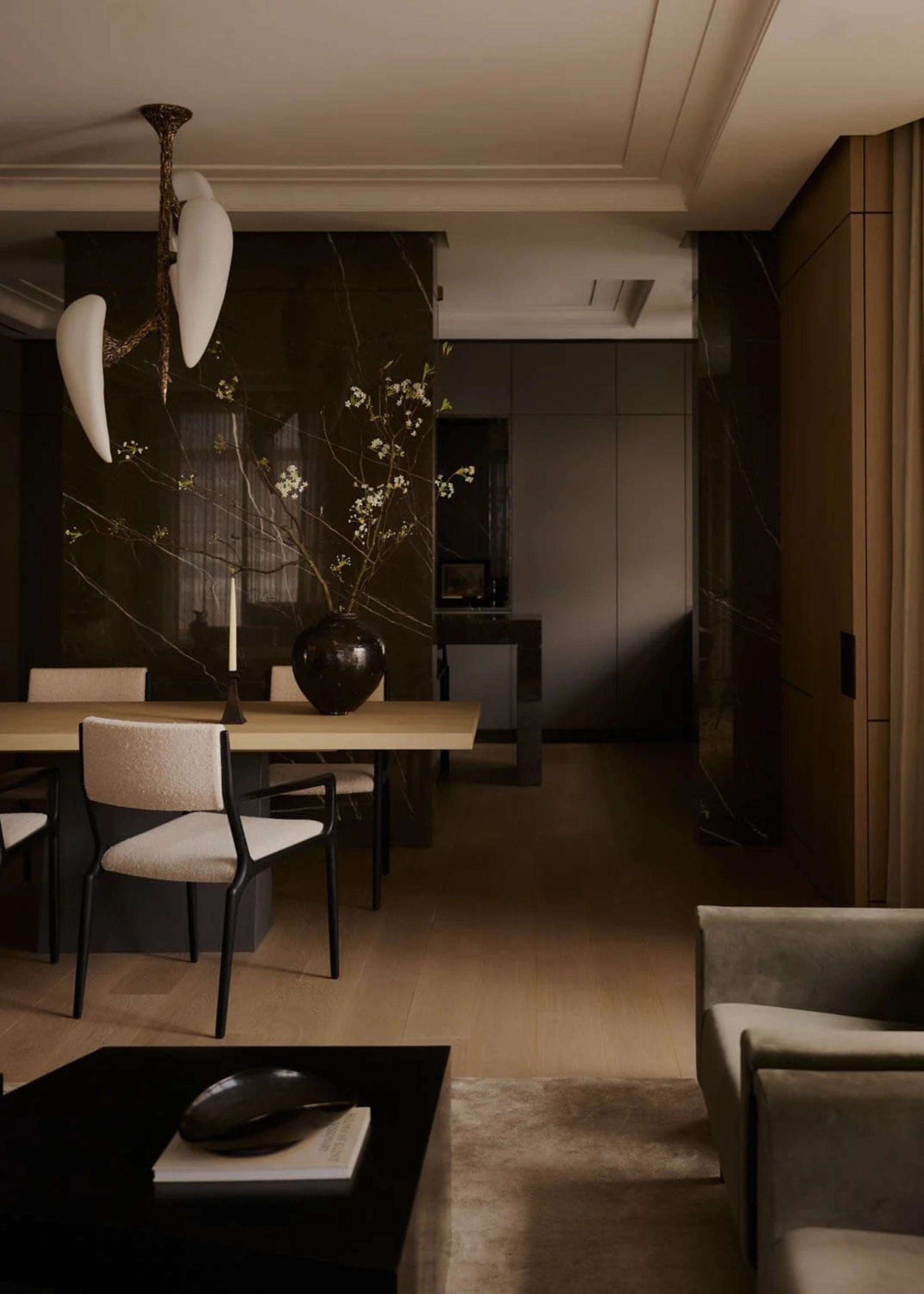 A dark woody living room near a dining set below a ceiling light