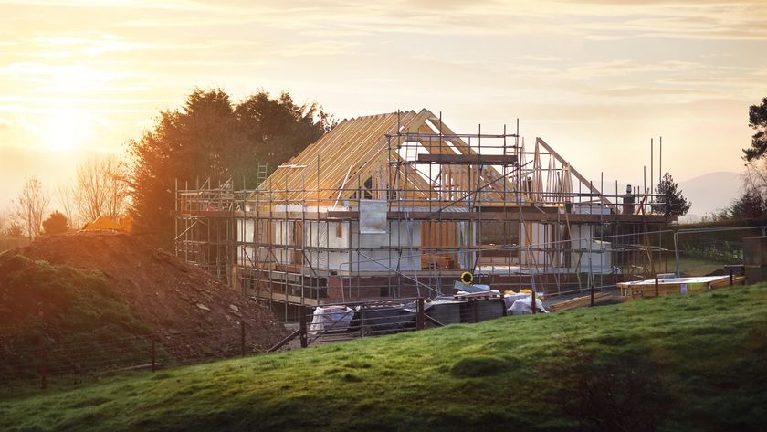 House under construction with green sloping land in front