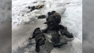 Photo of blackened human remains partially covered by snow and ice