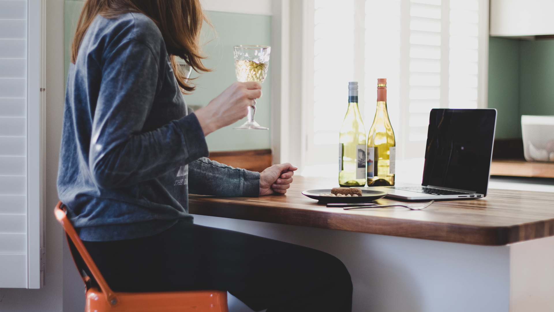 mujer bebiendo vino en su laptop