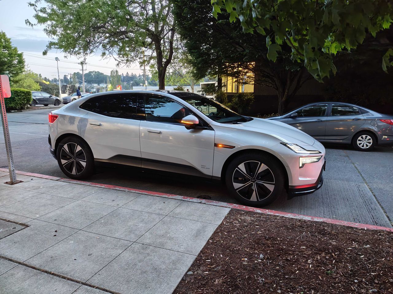 A Polestar 4 parked next to a sidewalk