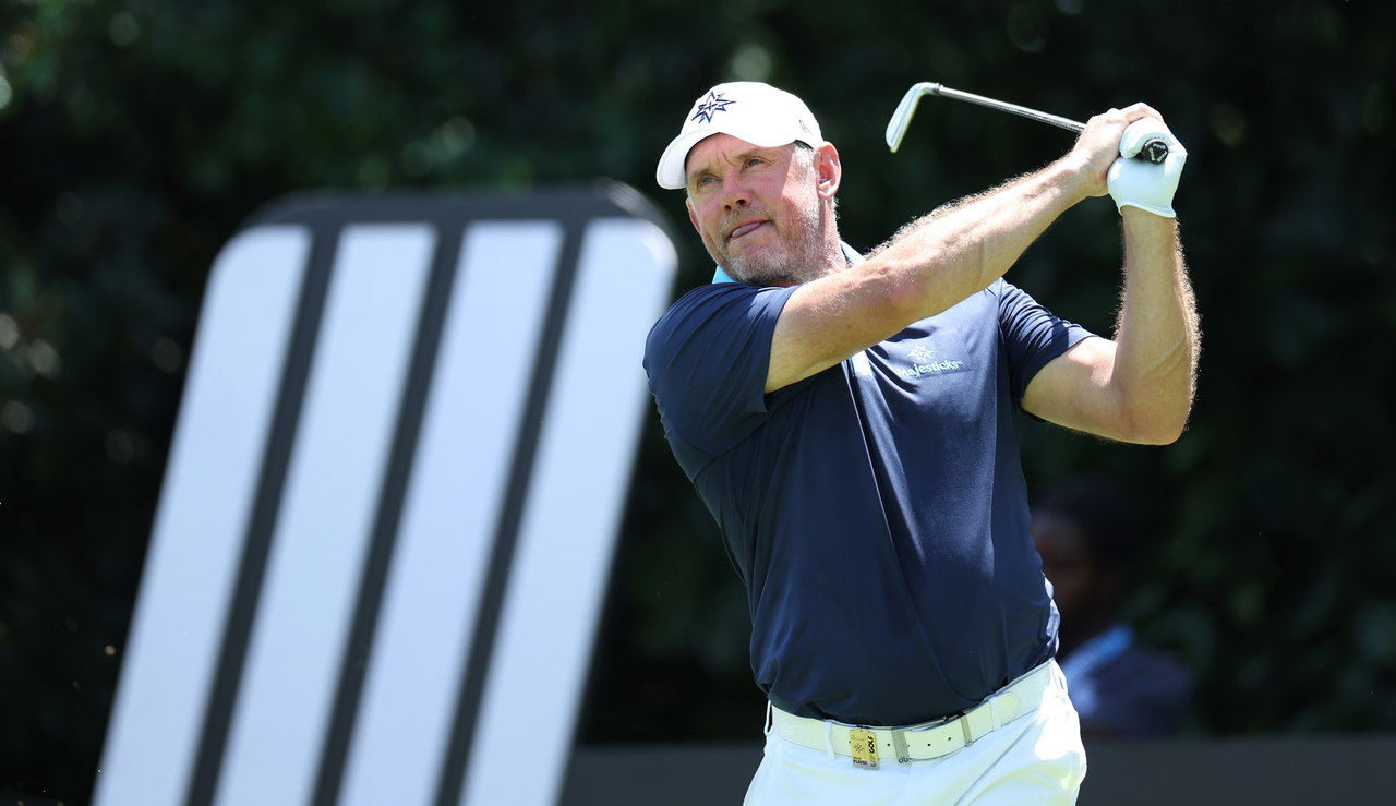 Lee Westwood strikes an iron shot and watches its flight