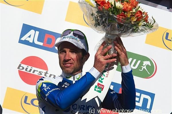 Michael Albasini (Orica-GreenEdge) hoists the winner's bouquet in St. Vallier